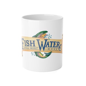 May include: A white ceramic mug featuring a graphic of a colorful trout fish curving through a tan scroll banner. The text on the banner reads FISH WATER in large blue letters with the smaller text STILL WANT MORE printed underneath.