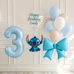 K&ouml;nnte beinhalten: Ein Ballonarrangement mit einer gro&szlig;en hellblauen Zahl Drei, einem transparenten Bubble-Ballon mit dem Text Happy Birthday Emily, einem blauen Stitch-Folienballon, einem gro&szlig;en blauen Schleifenballon und einer Gruppe hellblauer, wei&szlig;er und beiger Ballons.