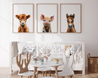 May include: Three framed animal prints featuring a calf, piglet, and foal. The prints are hung on a white wall above a white crib with a white and black striped pillow and a white bunny rabbit toy.