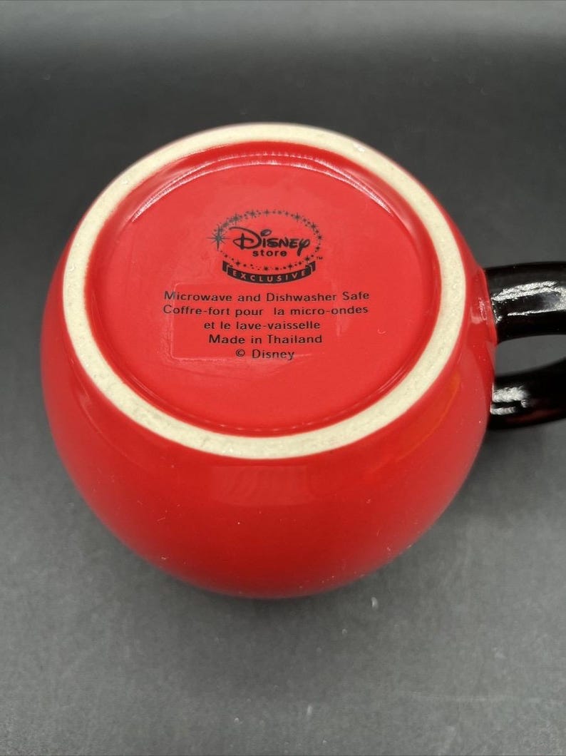 Pu&ograve; includere: Tazza in ceramica rossa con manico nero. Il fondo della tazza presenta il logo Disney Store e il testo che indica che &egrave; adatta al microonde e alla lavastoviglie. Prodotto in Thailandia.