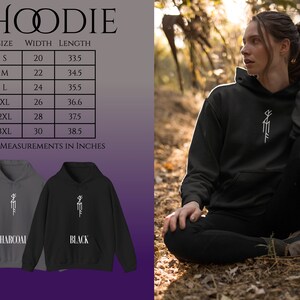 May include: A black and charcoal gray hoodie with a white graphic design. The hoodie has a drawstring hood and a kangaroo pocket. The size chart shows the width and length of the hoodie in inches.