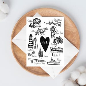 May include: A black and white illustration of Prince Edward Island (PEI) icons, including a lighthouse, lobster, potato, and a tractor. The word "PEI" is inside a black heart. The illustration is on a white card, resting on a wooden plate.