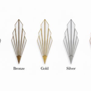 May include: Five wall sconces with a fan-shaped design, each featuring white panels framed by metal edges in black, bronze, gold, silver, and copper finishes. Each sconce has a pointed base and a symmetrical, tiered structure with vertical lines.