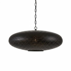 May include: A black, disc-shaped pendant light fixture featuring a textured surface with numerous small, perforated holes. The lamp is suspended from a matching black metal chain, creating a focused downward light through the intricate pattern.