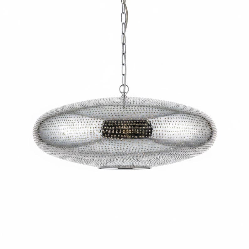 May include: A silver-toned, disc-shaped pendant light fixture with a textured, perforated surface pattern. The fixture is suspended by a thin metal chain and features a central opening at the bottom, showcasing a metallic finish throughout.