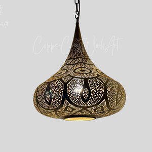May include: A black metal pendant light with a teardrop shape and intricate cut-out design. The light has a gold finish and is perfect for adding a touch of Moroccan style to any room.