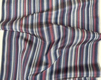 May include: Striped fabric in shades of blue, gray, and red. The fabric is woven with a subtle texture and has a soft, drapey feel.