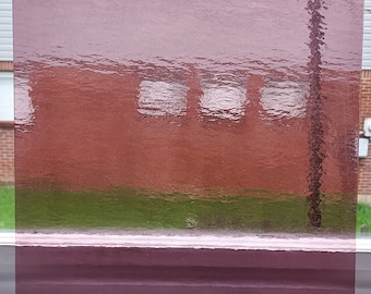 May include: A sheet of textured, translucent, light purple glass. The glass is slightly rippled and has a frosted appearance.