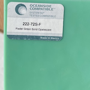 May include: A rectangular piece of pastel green glass with a label. The label reads "OCEANSIDE COMPATIBLE", "SYSTEM 96 TESTED COMPATIBLE", "222-72S-F", and "Pastel Green Solid Opalescent". The label also states "Made In Mexico".