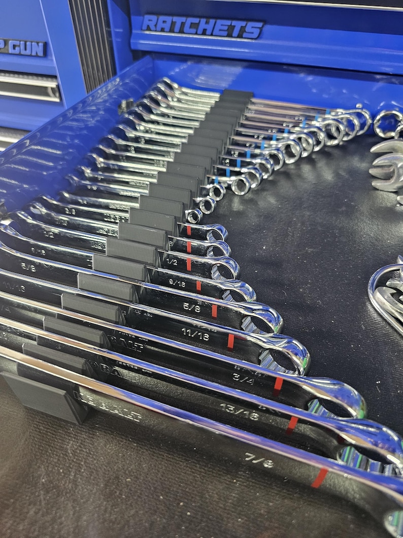 May include: A set of polished chrome wrenches, neatly organized in a blue toolbox drawer. The wrenches are labeled with fractional inch measurements, and the drawer is labeled "RATCHETS".