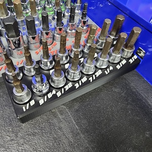 May include: A white ceramic mug with a black handle and the text "But first, coffee" in a handwritten style. The mug is on a white surface. The mug is approximately 4 inches tall.