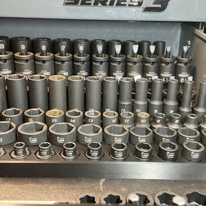 May include: A collection of dark gray automotive sockets of various sizes, arranged neatly in a storage tray. The sockets are labeled with metric measurements, ranging from 8mm to 24mm, and are designed for automotive repair and maintenance.