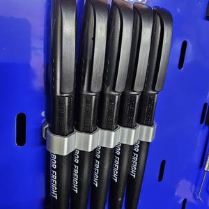 May include: A set of five black tools with silver holders, mounted on a blue pegboard. The tools have the words "BOR FREIGHT" printed on them.