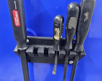 May include: A collection of black screwdrivers and pry bars are displayed in a black holder against a blue background. The tools vary in size and shape, with some showing wear. One tool is labeled "Hyper Tough" and "Made in USA".