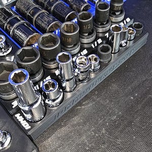 May include: A set of three ceramic mugs with a speckled, matte finish. The mugs are in shades of cream, light gray, and dark gray. Each mug has a simple, minimalist design and a rounded handle.