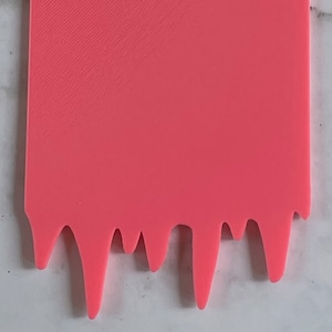 May include: A pink plastic drip-shaped sign with a smooth surface. The sign is blank and ready for customization.