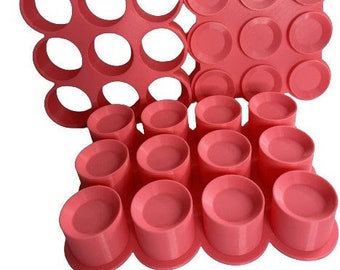 May include: A pink silicone baking mold with 24 round cavities. The mold is designed for making small cakes, cookies, or other treats.