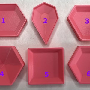 May include: Six pink plastic trays of different shapes. The trays are numbered 1 through 6.