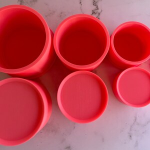 May include: A set of seven pink silicone molds of varying sizes, perfect for creating different sized cakes or other desserts.