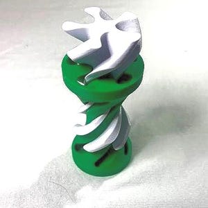 May include: A 3D-printed sculpture featuring a green base and a white, abstract top. The sculpture has a twisted, spiral design with a smooth finish. The color scheme is a combination of bright green and white.