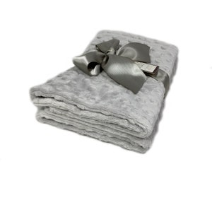 May include: A folded, light gray blanket with a textured surface and a satin ribbon tied in a bow. A small tag is attached to the ribbon. The blanket is made of a soft, plush material.