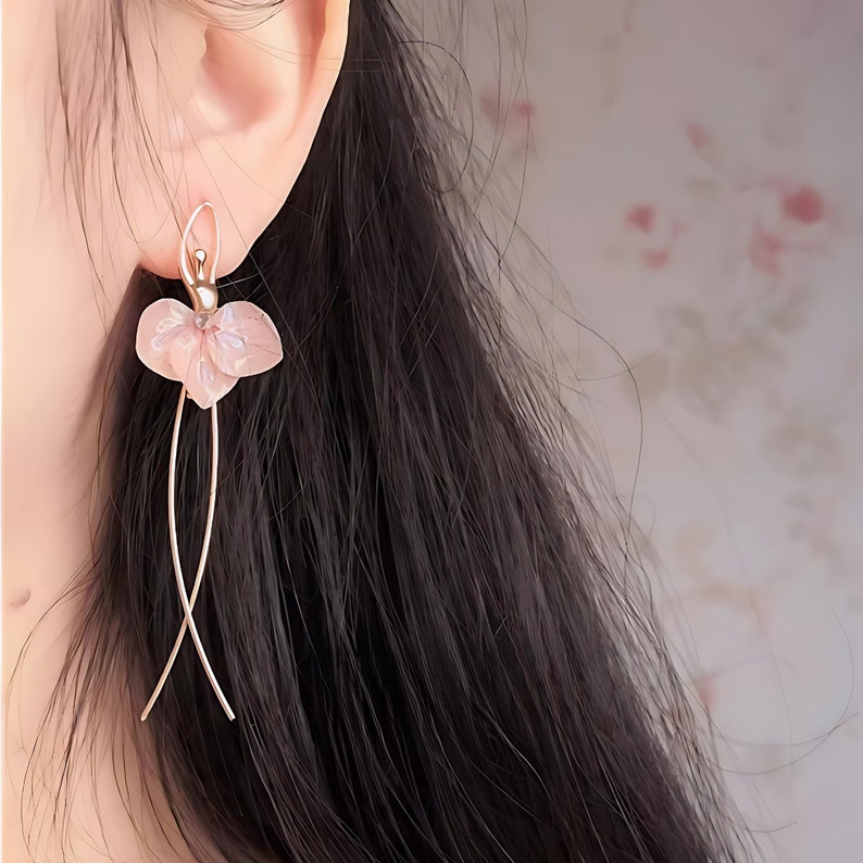 Close up of a model wearing the pink ballerina earrings, highlighting the whimsical fairycore aesthetic of the jewelry.