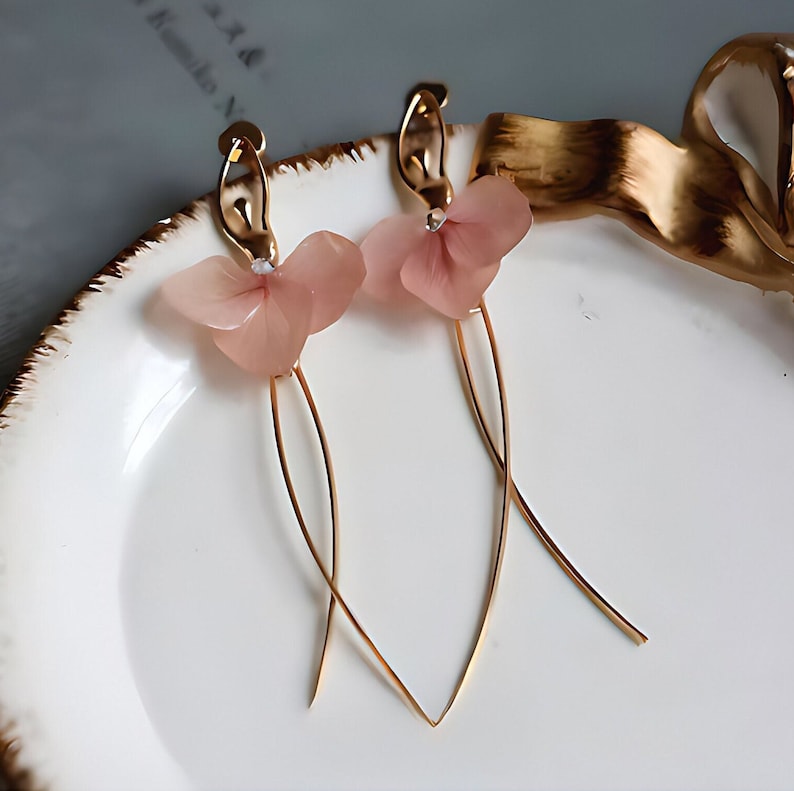 A close-up detail shot of the pink resin flower earrings, showing the delicate texture of the real pressed flower petals.