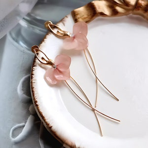 A close-up detail shot of the pink resin flower earrings, showing the delicate texture of the real pressed flower petals.