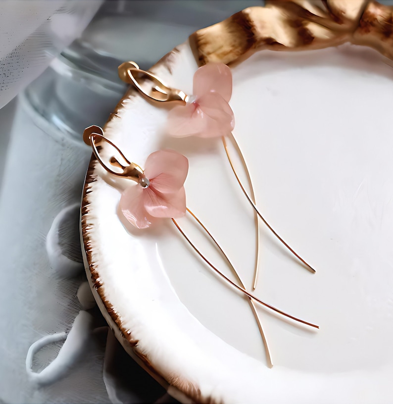 A close-up detail shot of the pink resin flower earrings, showing the delicate texture of the real pressed flower petals.