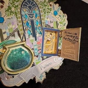 Può includere: Spilla smaltata dettagliata a tema preparazione di pozioni. La spilla include una vetrata, bottiglie di pozioni e un libro che recita "Advanced Potion Making". Un banner recita "Potions Class".