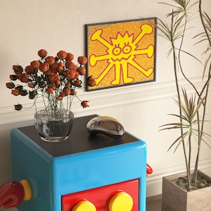 May include: A colorful room scene featuring a blue and red cabinet with yellow accents, topped with a clear vase of orange roses and a silver computer mouse. A framed yellow and red artwork hangs on the wall.