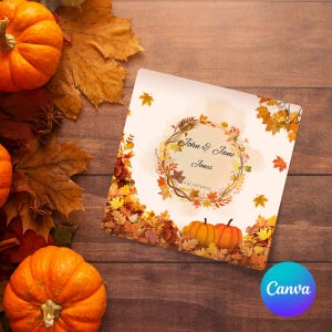 Op de afbeelding: Een herfstthema uitnodigingskaart met de tekst "John & Jane Jones" omringd door een bloemenkrans. De kaart toont pompoenen en herfstbladeren. De achtergrond is een houten oppervlak met pompoenen en bladeren.