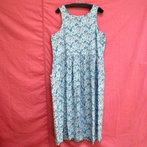 May include: A sleeveless, blue and white floral print dress with a gathered skirt and pockets.