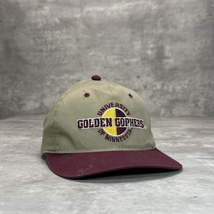 May include: A khaki baseball cap with a maroon peak and top button. The cap displays the text "UNIVERSITY OF MINNESOTA GOLDEN GOPHERS" in maroon and yellow lettering.