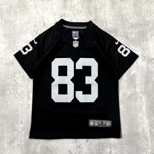 Op de afbeelding: Een zwart football-shirt met korte mouwen en het nummer 83 in grote witte cijfers op de voorzijde en de mouwen. Het shirt is voorzien van een NFL-logo bij de hals, een Nike-logo op de mouw en een label met de maat S aan de onderzijde.