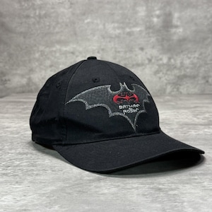 Peut inclure: Une casquette de baseball noire avec un emblème brodé en forme de chauve-souris grise sur le devant. Au centre de l'emblème se trouve un symbole de chauve-souris rouge au-dessus du texte blanc Batman Robin. La casquette a une calotte structurée.