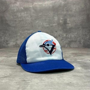 May include: A blue and white baseball cap with a blue bird logo and the word "Toronto" embroidered on the front.