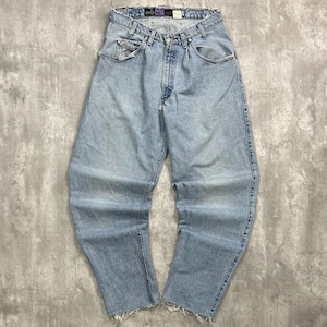 May include: Light blue denim jeans featuring a high-waisted fit, a button and zipper fly closure, and five pockets. The waistband and leg hems have a raw, frayed edge finish. The denim has a faded wash with light whiskering at the hips.