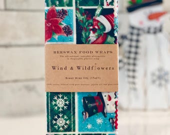 May include: A set of three beeswax food wraps with a Christmas-themed design. The wraps are made of 100% cotton infused with beeswax, jojoba oil, and pine resin. The largest wrap is labelled "Bread Wrap XXL (17x21)".