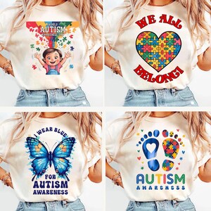 K&ouml;nnte beinhalten: Vier verschiedene T-Shirt-Designs mit dem Text "World Autism Awareness Day", "I Wear Blue For Autism Awareness", "We All Belong" und "Autism Awareness" mit Puzzle-St&uuml;ck-Designs.
