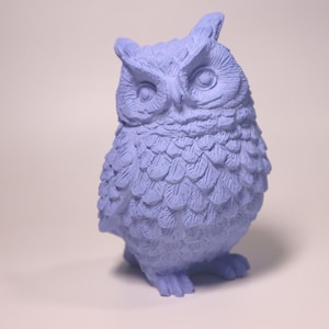 May include: A light blue ceramic owl figurine with detailed feathers and large, round eyes.