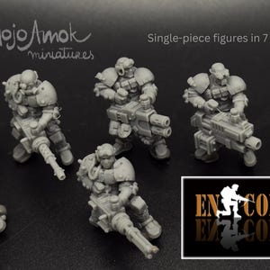 May include: A collection of seven gray miniature figures in various poses, each holding a large weapon. The figures are single-piece and appear to be part of a science fiction or fantasy theme. The image includes text that reads "MojoAmok miniatures" and "Single-piece figures in 7 poses."