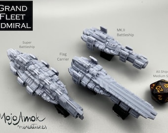 Puede incluir: Se muestran tres modelos de naves espaciales grises en miniatura, incluyendo un Super Acorazado, un Portaaviones y un Acorazado MK.II. El texto "GRAND FLEET ADMIRAL" está en la parte superior. También hay un dado de veinte caras.
