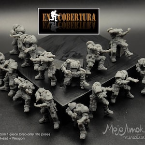 May include: A collection of gray miniature figures in various action poses, likely for tabletop gaming. The figures are detailed with armor and weaponry. The image includes text that reads "EN COBERTURA" and "Mojo Amok miniatures."