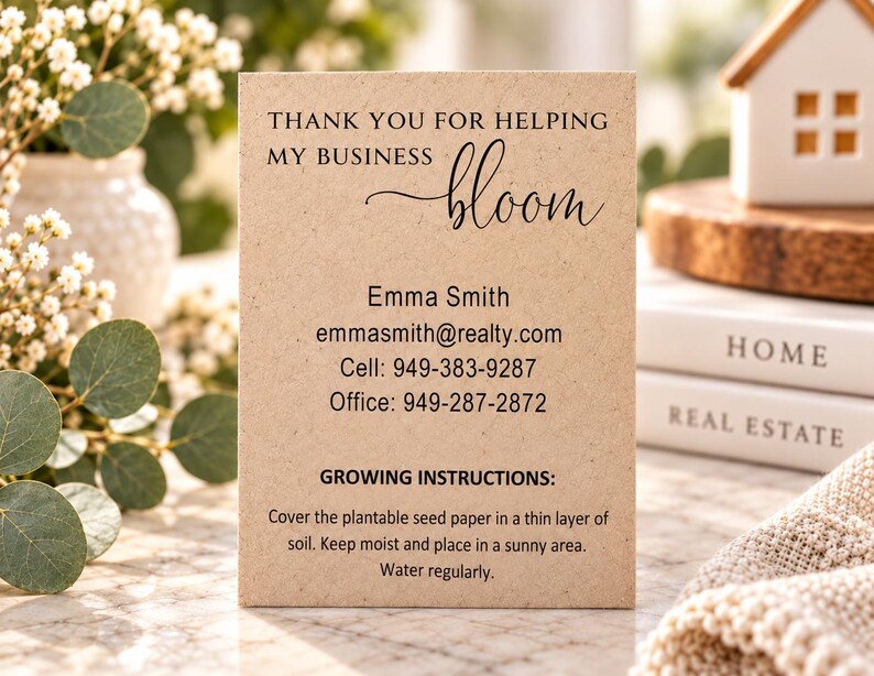 May include: A rectangular tan card with black text reading: THANK YOU FOR HELPING MY BUSINESS bloom, Emma Smith, emmasmith@realty.com, Cell: 949-383-9287, Office: 949-287-2872, GROWING INSTRUCTIONS: Cover the plantable seed paper in a thin layer of soil.