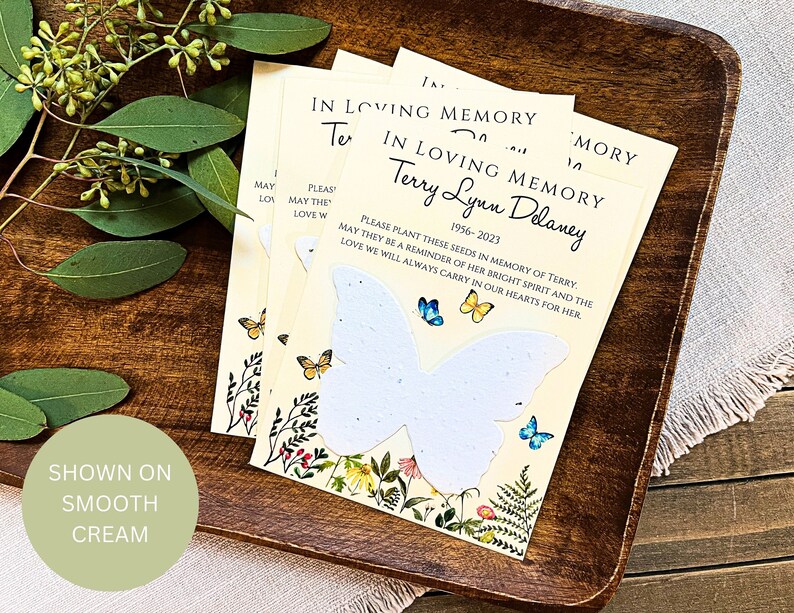 Peut inclure: Un ensemble de trois cartes de couleur cr&egrave;me avec un motif de papillon. Les cartes portent un message qui dit "En souvenir affectueux de Terry Lynn Delaney 1956-2023. Veuillez planter ces graines en m&eacute;moire de Terry. Puissent-elles &ecirc;tre un rappel de son esprit lumineux et de l'amour que nous porterons toujours dans nos c&oelig;urs pour elle."