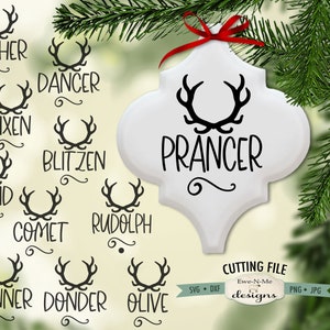 May include: A white Christmas ornament with the word "Prancer" in black script, tied with a red ribbon. The ornament features a reindeer antler design. Additional text includes the names of other reindeer and "Cutting File" with file type icons.
