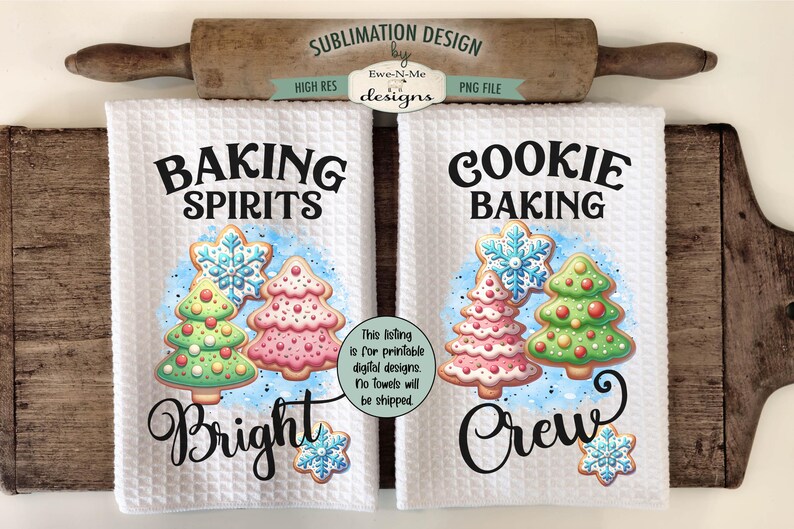 Op de afbeelding: Twee witte keukenhanddoeken met wafelweefsel met vakantiethema's. Op de ene handdoek staat "Baking Spirits Bright" en op de andere "Cookie Baking Crew". Elk heeft een kerstboomkoekjesontwerp. Een houten deegroller en snijplank staan op de achtergrond.