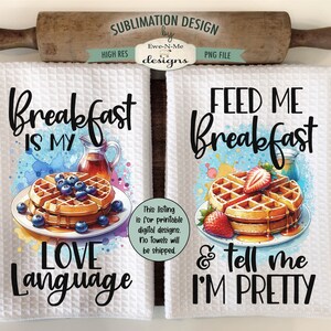 May include: Two white kitchen towels with watercolor designs of waffles, blueberries, and strawberries. The text on the towels reads "Breakfast is my love language" and "Feed me breakfast & tell me I'm pretty".