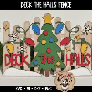 Puede incluir: Decoración navideña de madera con una valla, un árbol de Navidad verde, luces de cadena y las palabras "DECK THE HALLS". El árbol tiene una estrella amarilla y adornos coloridos. La valla está decorada con copos de nieve y estrellas.